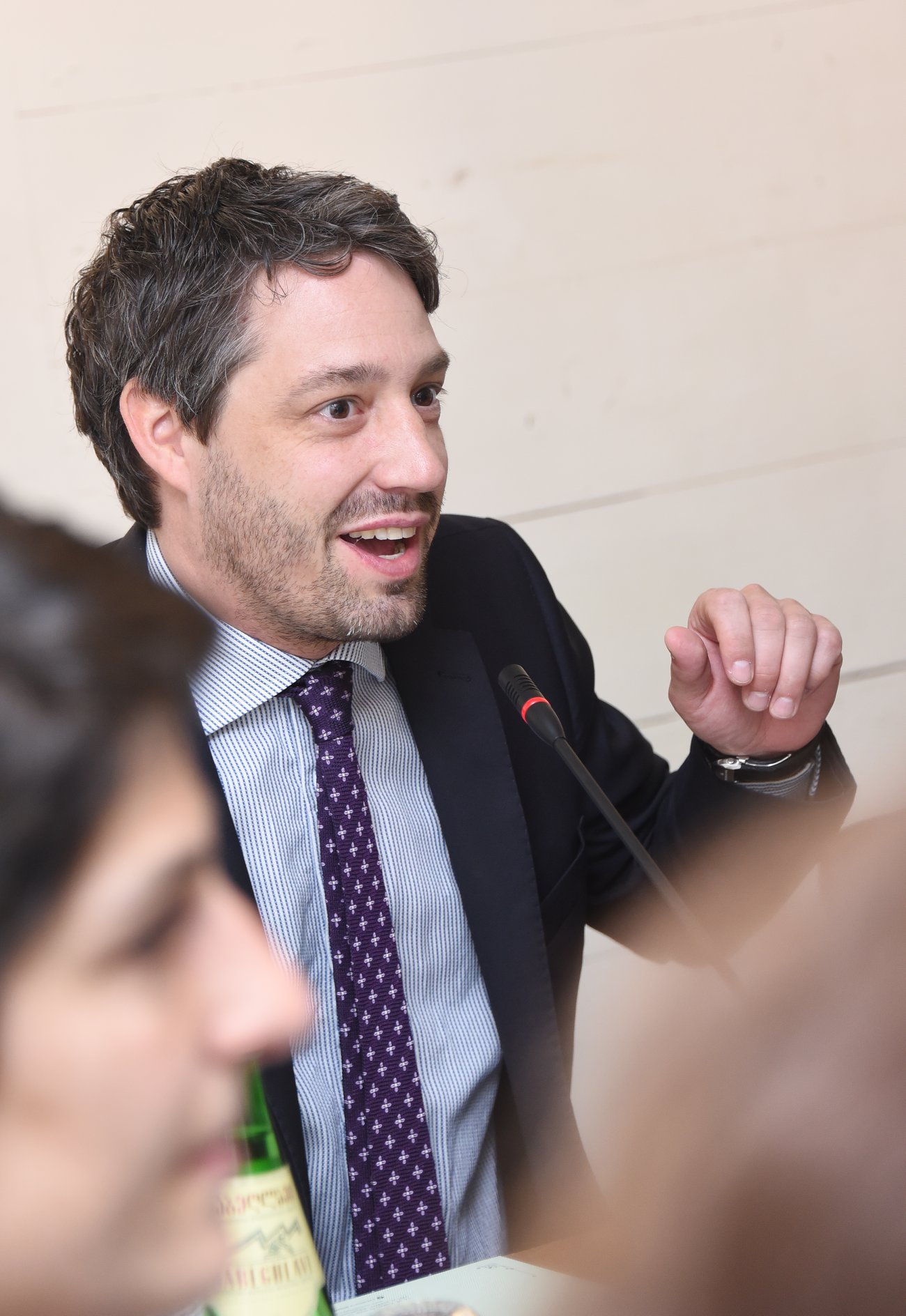 A photograph of Philippe Rudaz speaking animately into a microphone.
