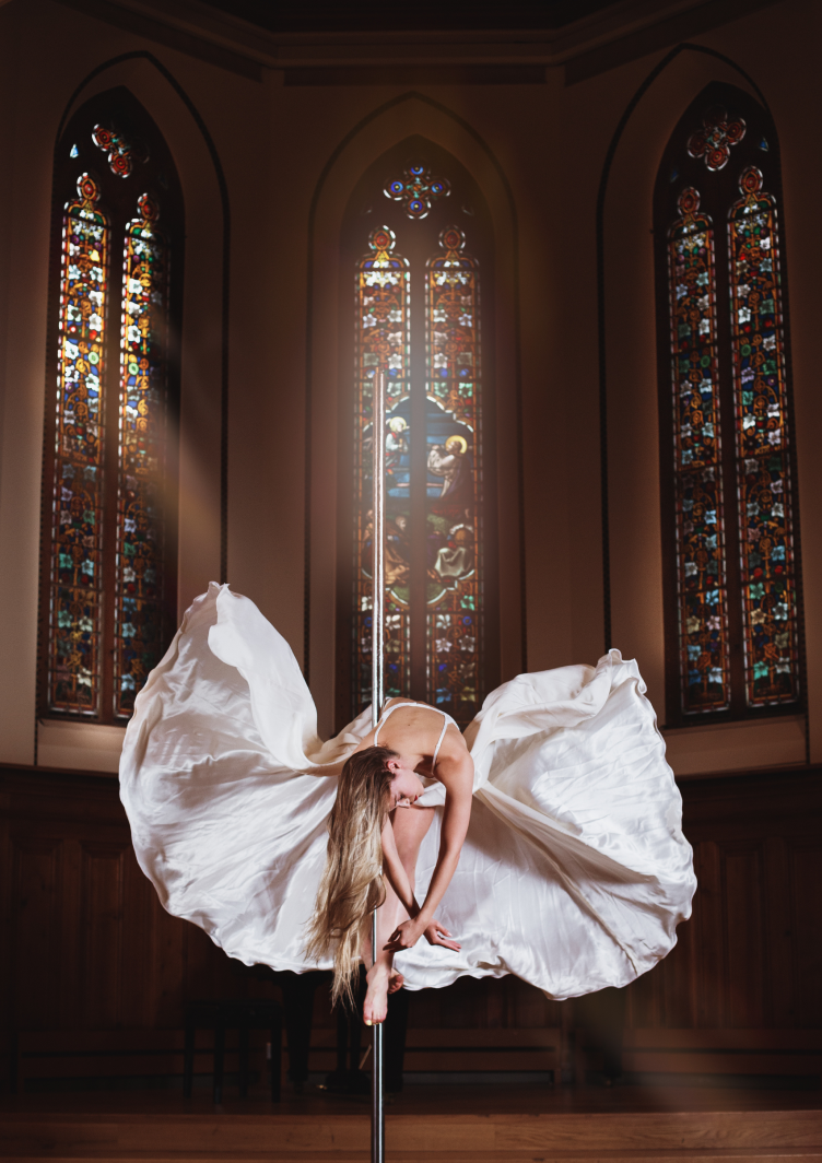 A photograph of Dr Laura Joan Salm dancing inside a church-like building.